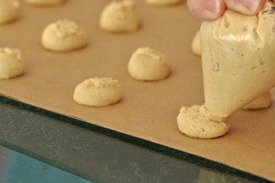 Pipe out gluten free vanilla wafer dough onto parchment-lined baking sheets.