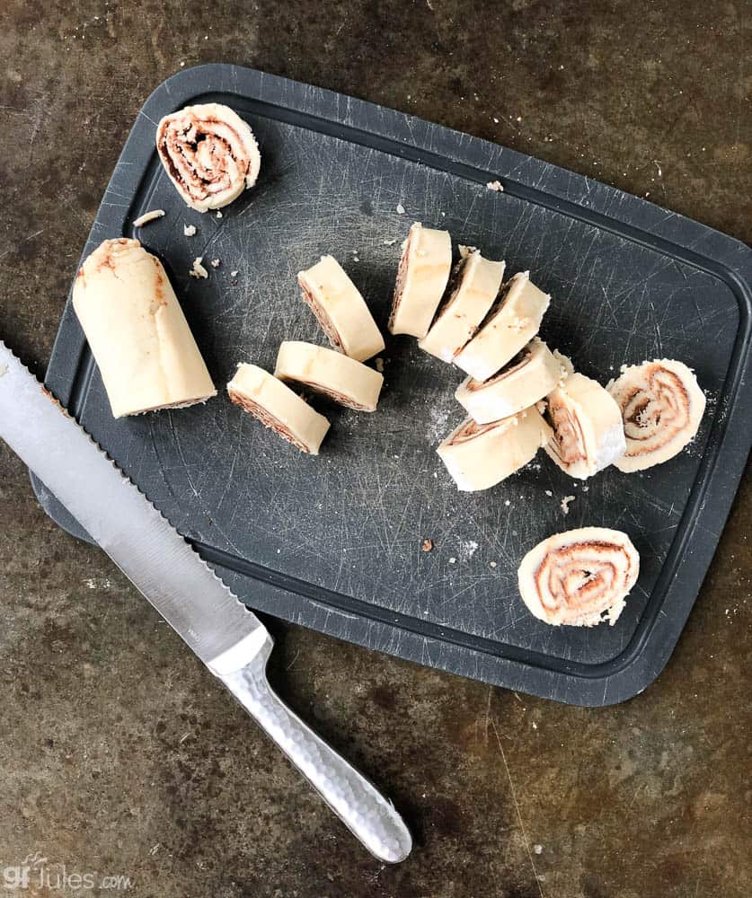 gluten free cinnamon roll cookie dough rolled and sliced with knife