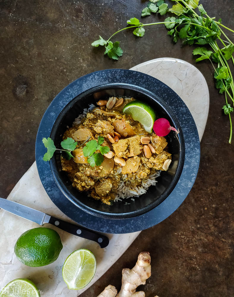 gluten free massaman curry in bowl with limes