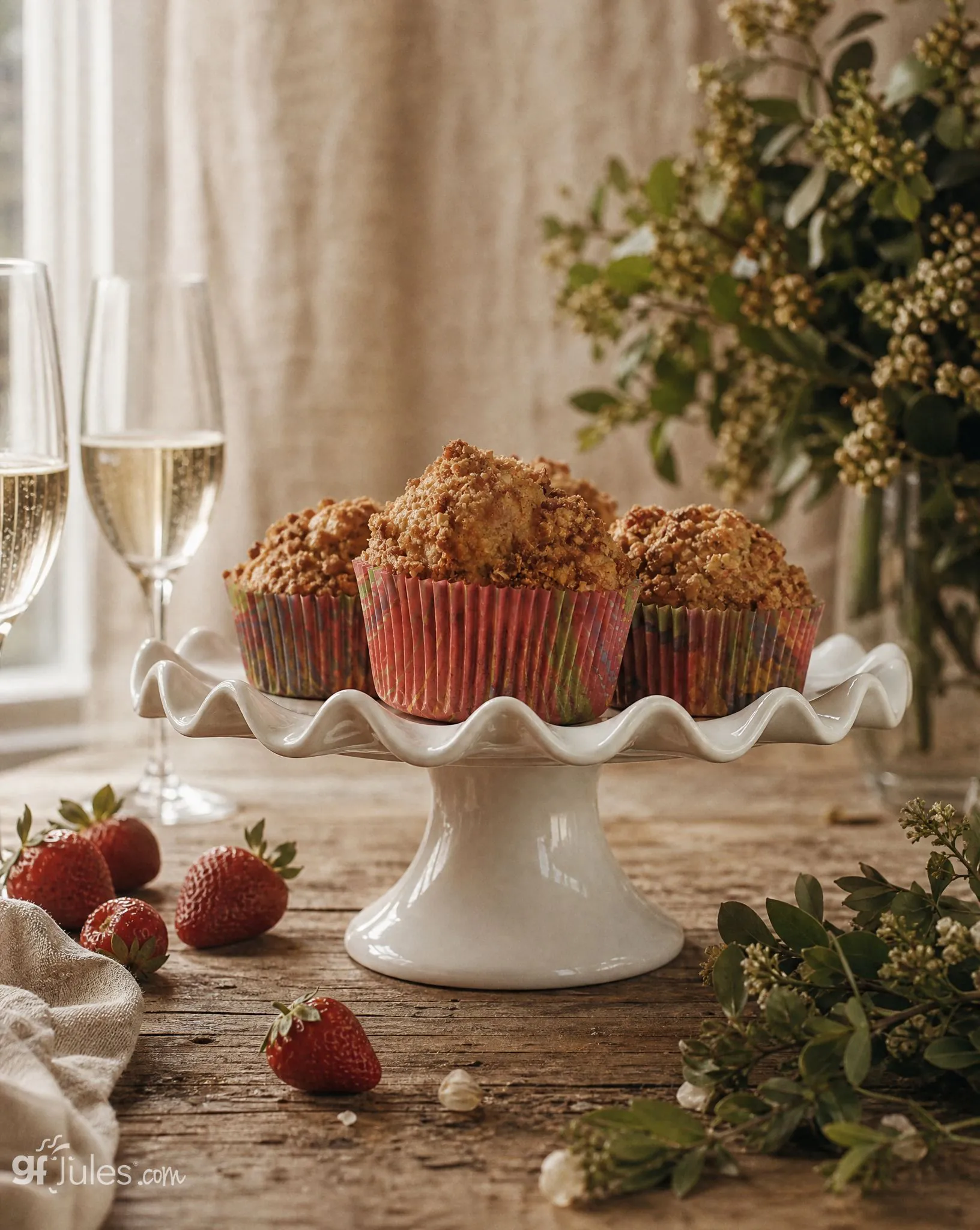 gluten free strawberry rhubarb muffins on pedestal by window