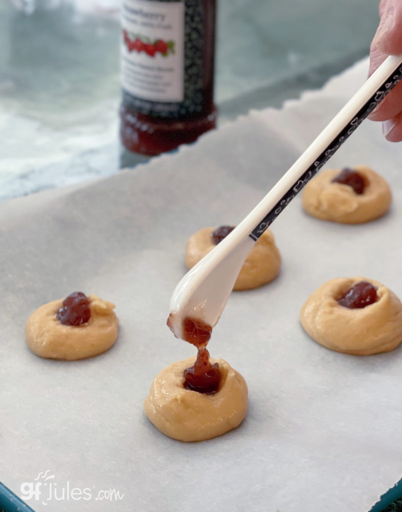 gluten free thumbprint cookies on tray with jam