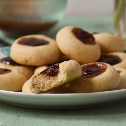 gluten free thumbprint cookies on plate with bite CU| gfJules