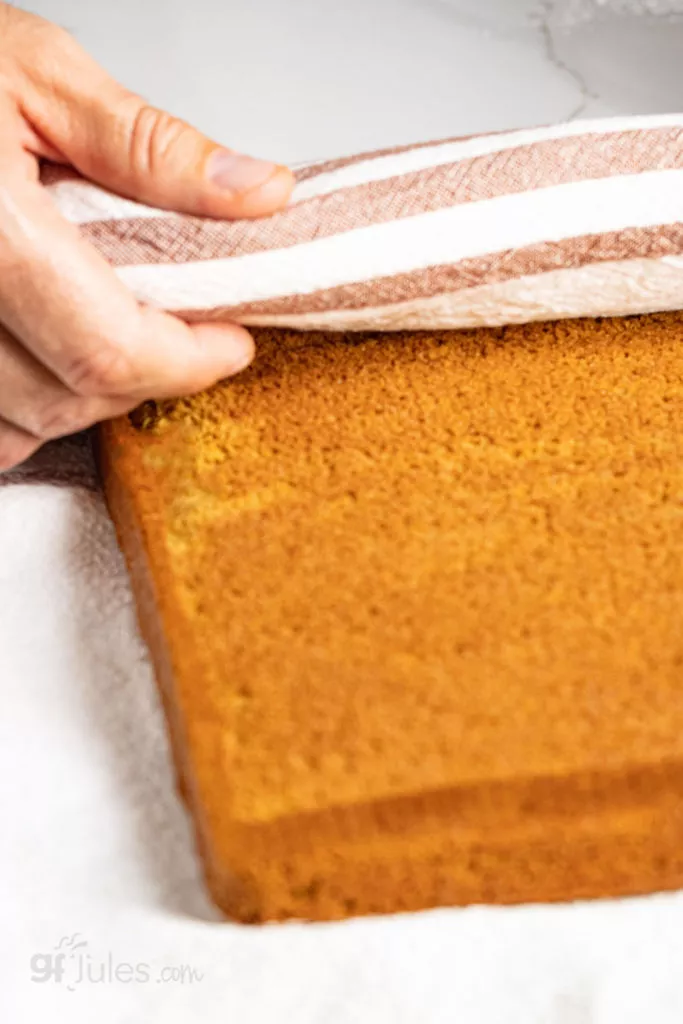 Gluten Free Pumpkin Roll hot out of the oven, rolled gently in tea towel dusted with confectioner's sugar; Photograph by: R.Mora Photography.