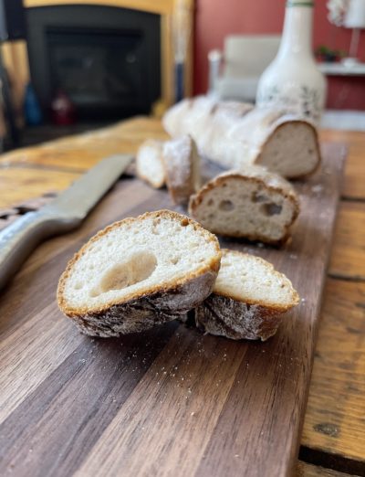 Sliced Gluten Free Baguette on cutting board with knife