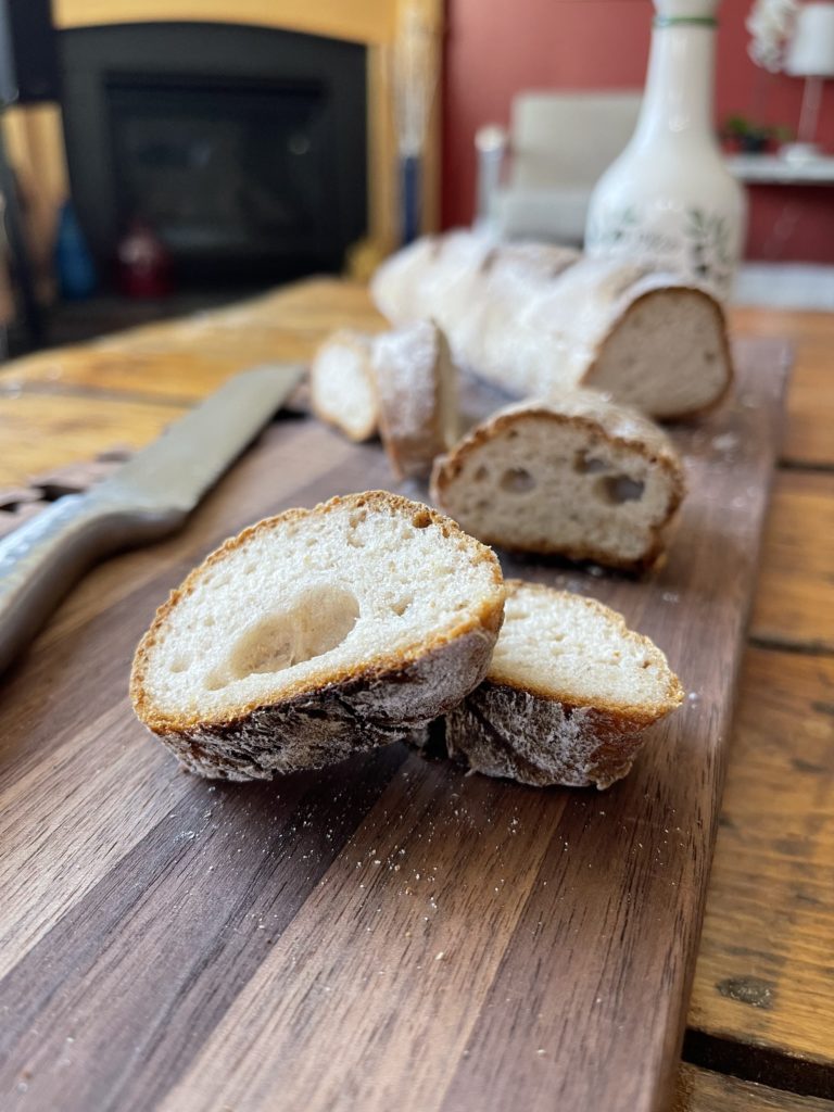 Sliced Gluten Free Baguette on cutting board with knife