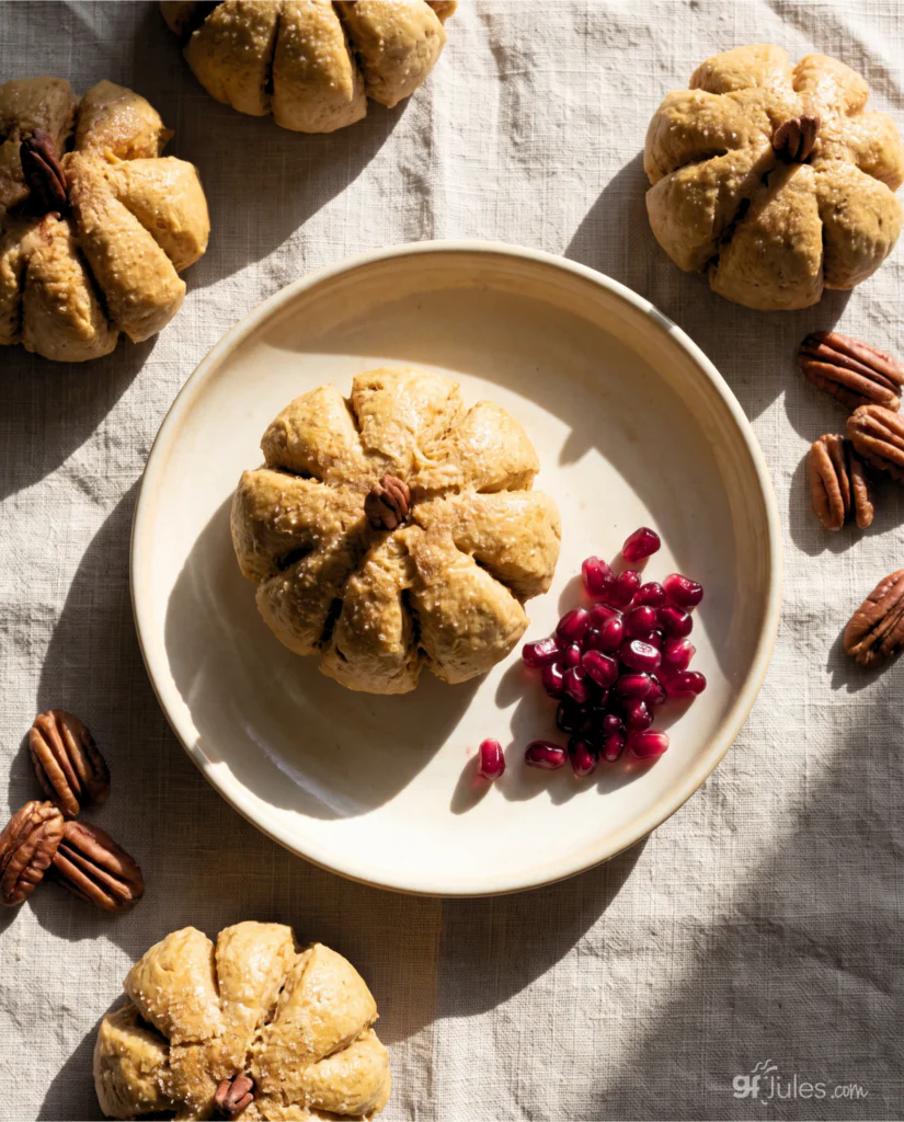 Gluten Free Pumpkin Shaped Dinner roll Overhead with pomegranate seeds