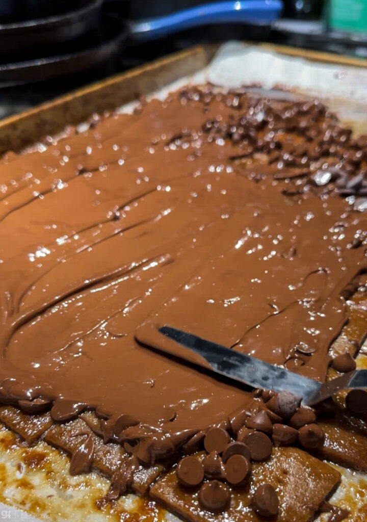 spreading melted chocolate on graham crackers