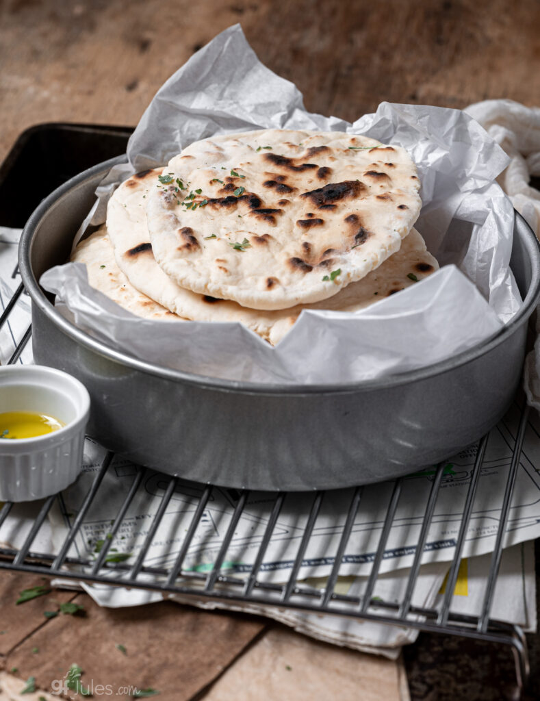 Gluten free naan bread cooked in a cast iron skillet with golden brown spots