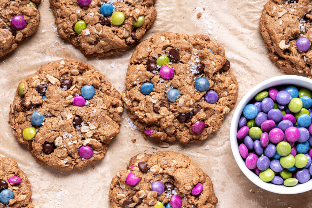 Overhead view of gluten free monster cookies made with gfJules Flour, packed with peanut butter, oats, chocolate chips, and candy pieces.