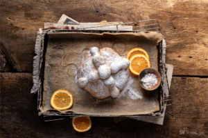 gluten free pan de muerto overhead on pan with orange slices